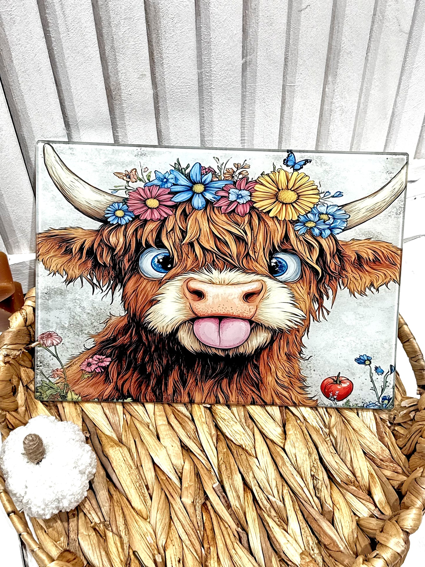 Cartoon highland cow with floral headband on a woven surface