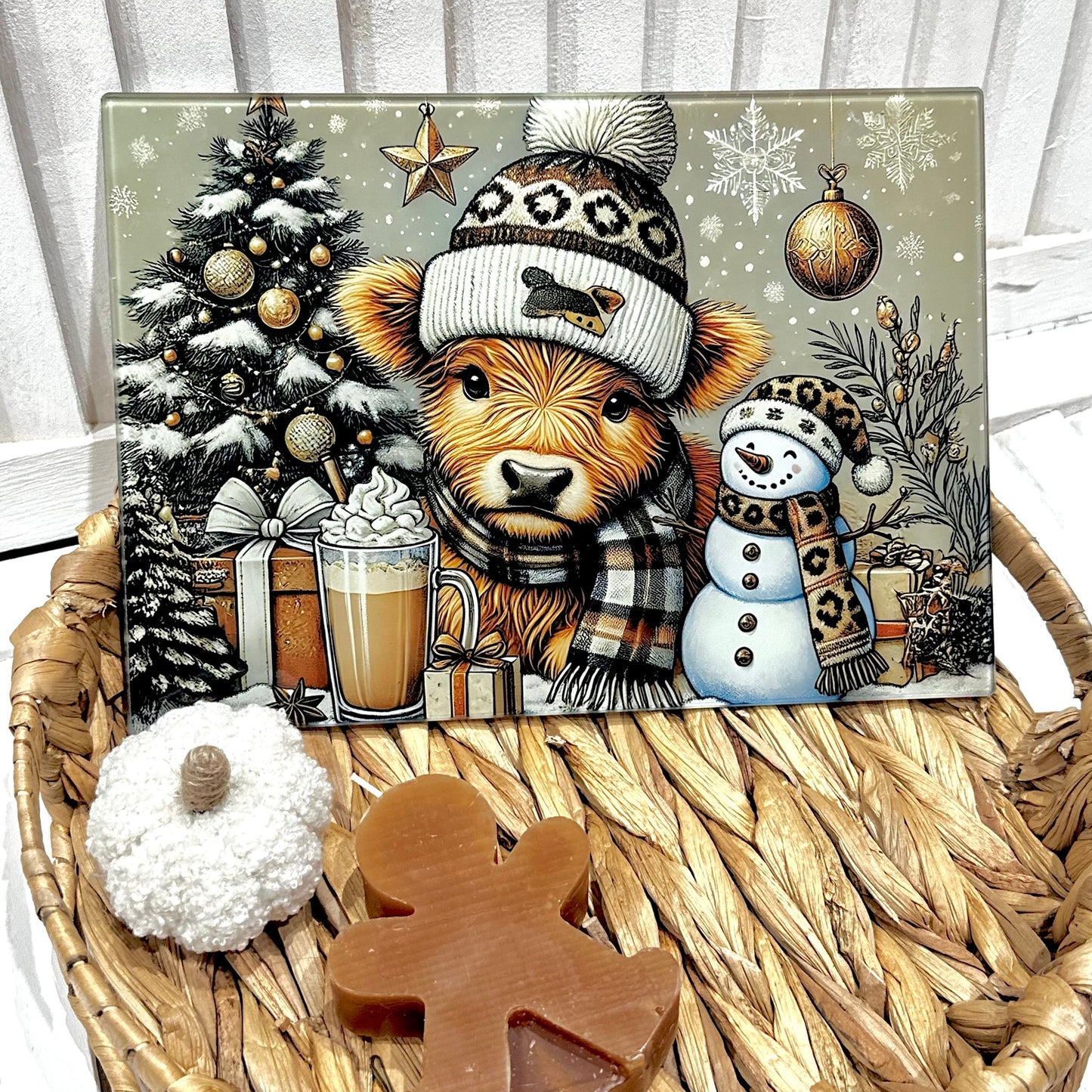 Christmas-themed decorative chopping board with a bear, snowman, and tree on a woven basket.